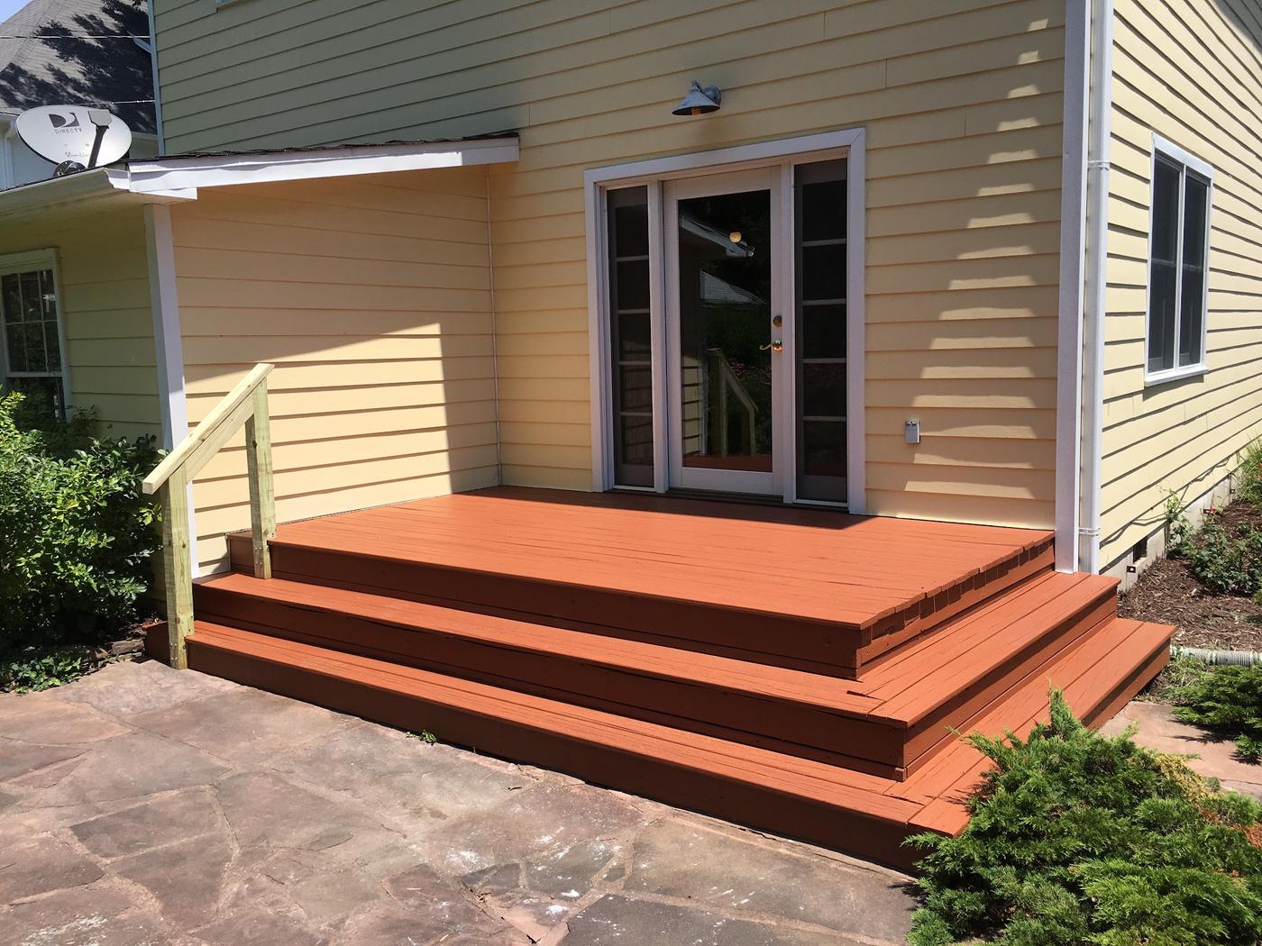 A deck landing with wrapped steps and a new handrail post, stained and finished.
