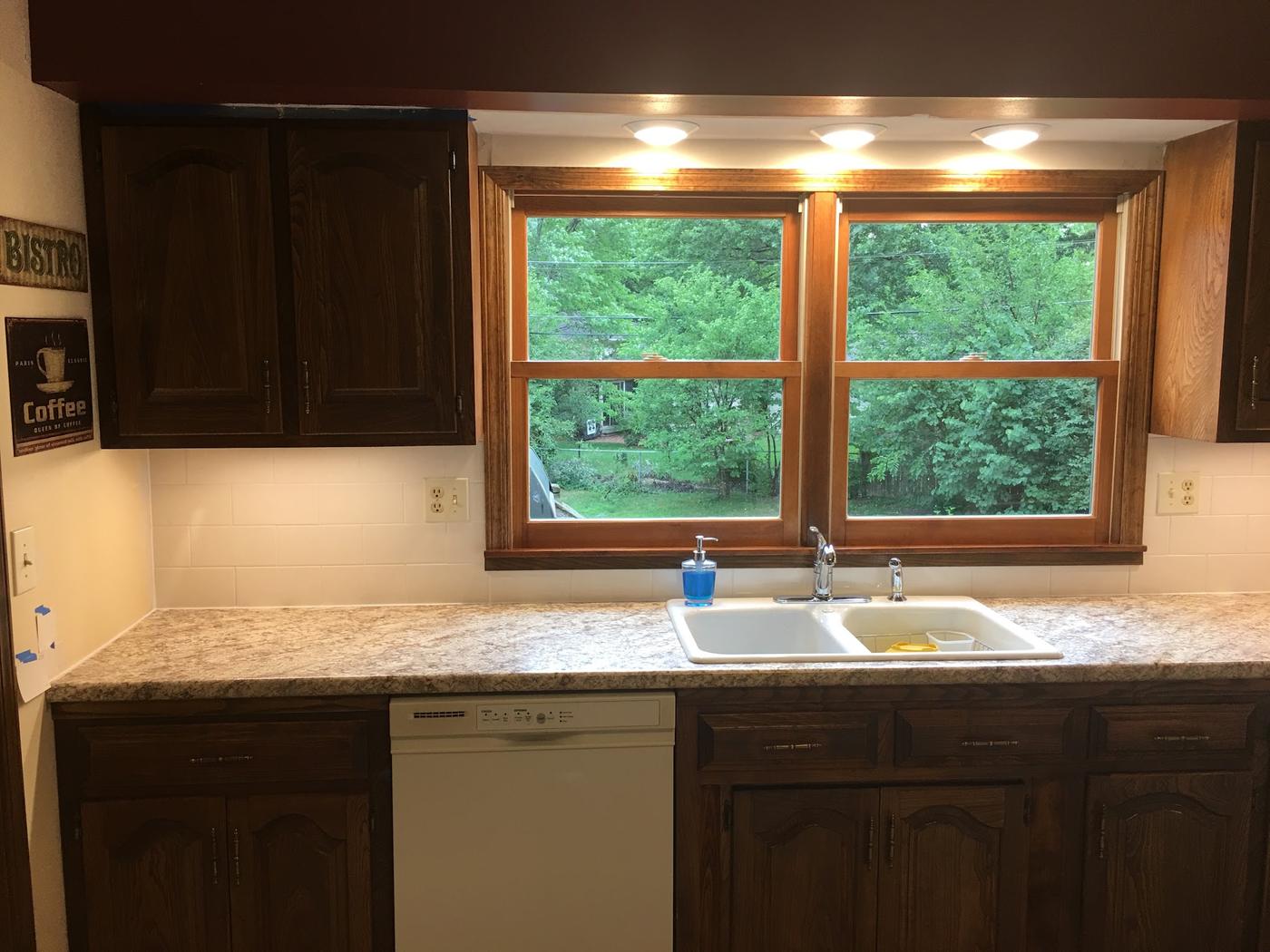 A speckled counter, a new drop-in double sink and faucet, and lights under the cabinets.