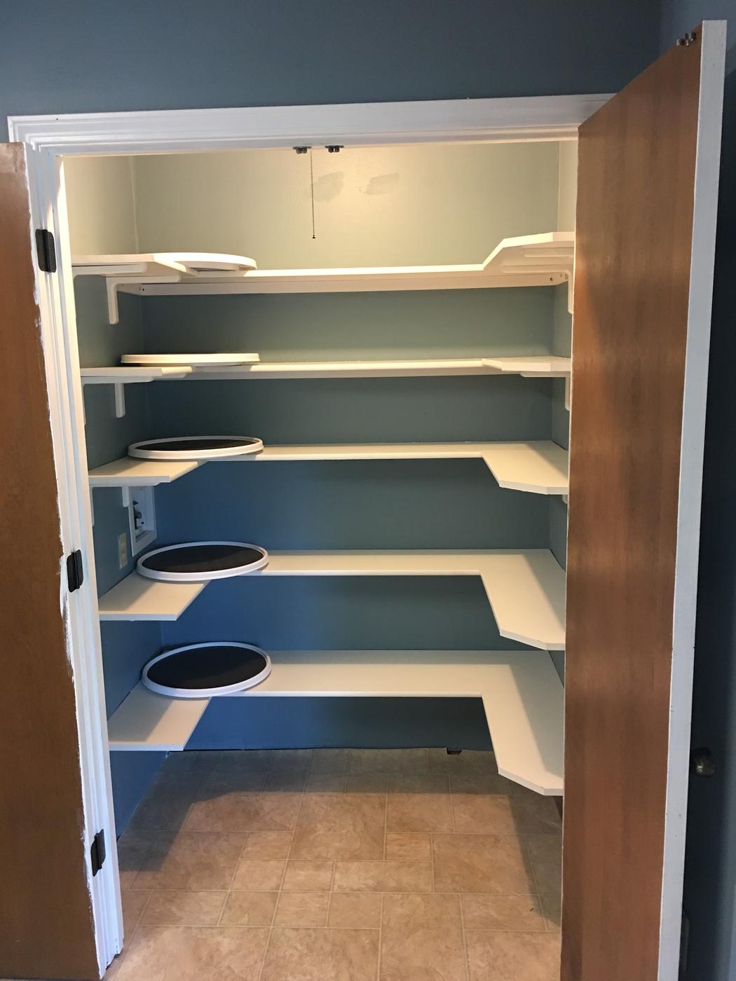A pantry fitted with custom wraparound shelving and corner turntables